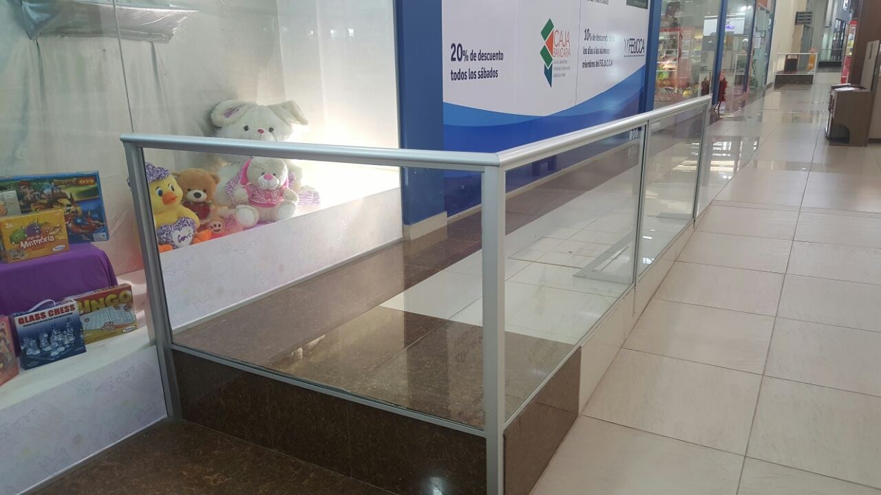 Baranda de vidrio con perfilería de aluminio en el entrepiso de una galería comercial · MÁS VIDRIOS