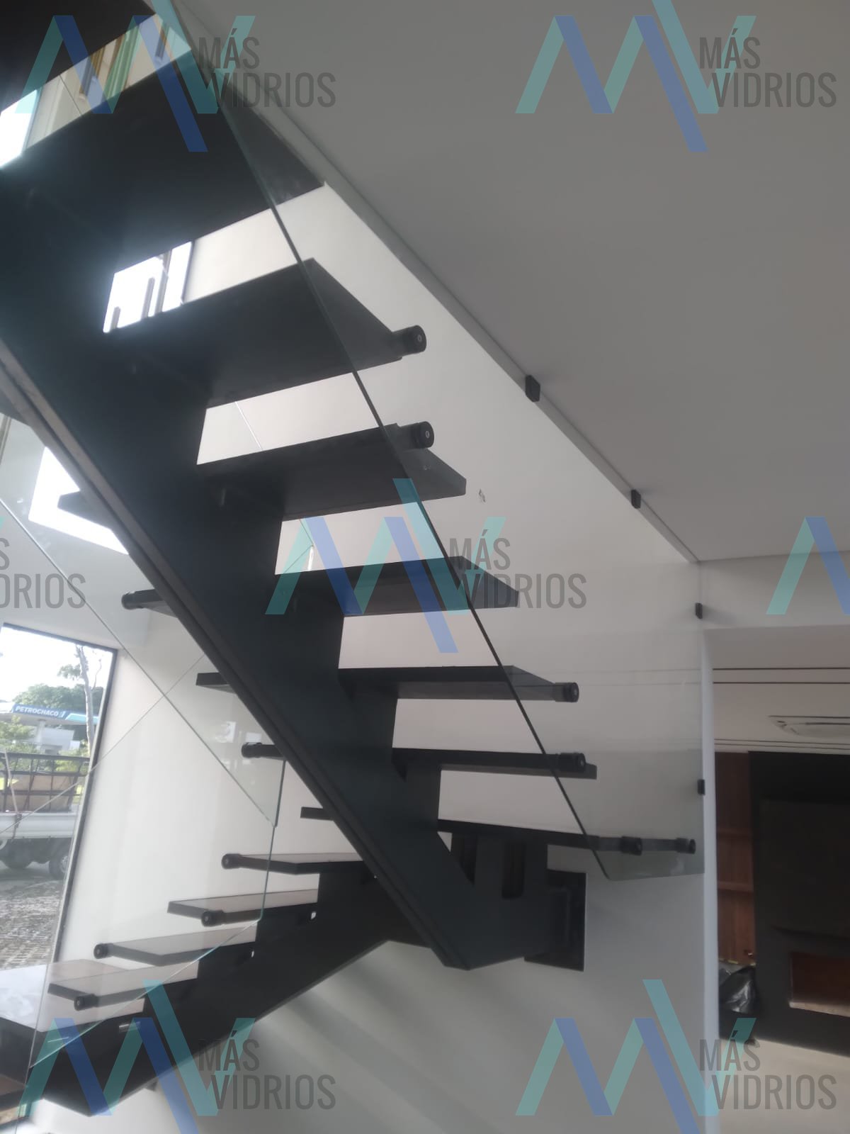 Baranda de vidrio templado con herrajes en escalera metálica moderna · MÁS VIDRIOS