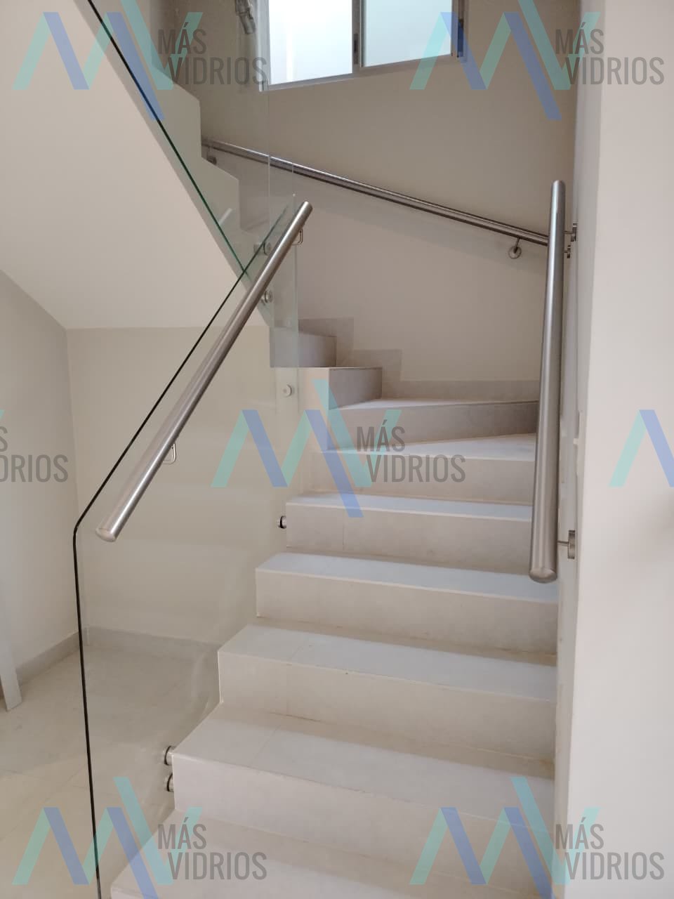 Baranda de vidrio con pasamanos de acero inoxidable en escalera residencial · MÁS VIDRIOS