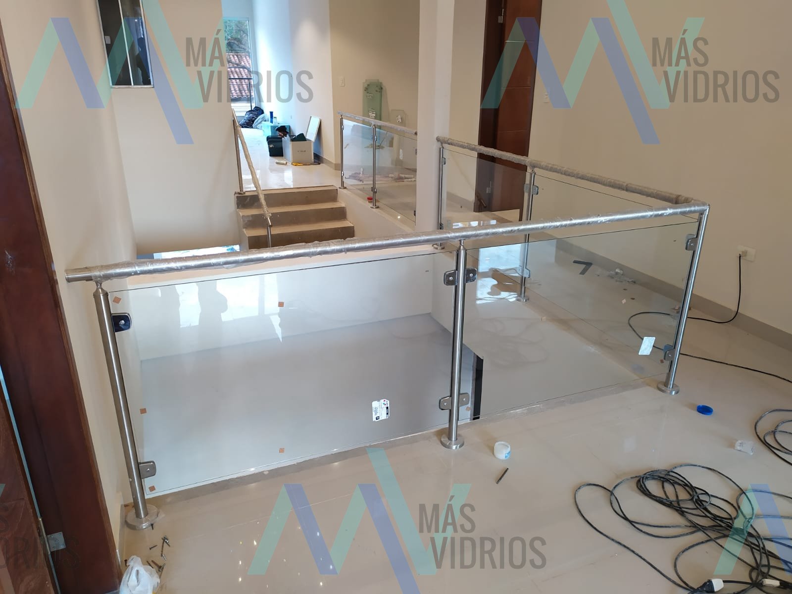 Baranda de vidrio con parantes de acero inoxidable en entrepiso residencial · MÁS VIDRIOS