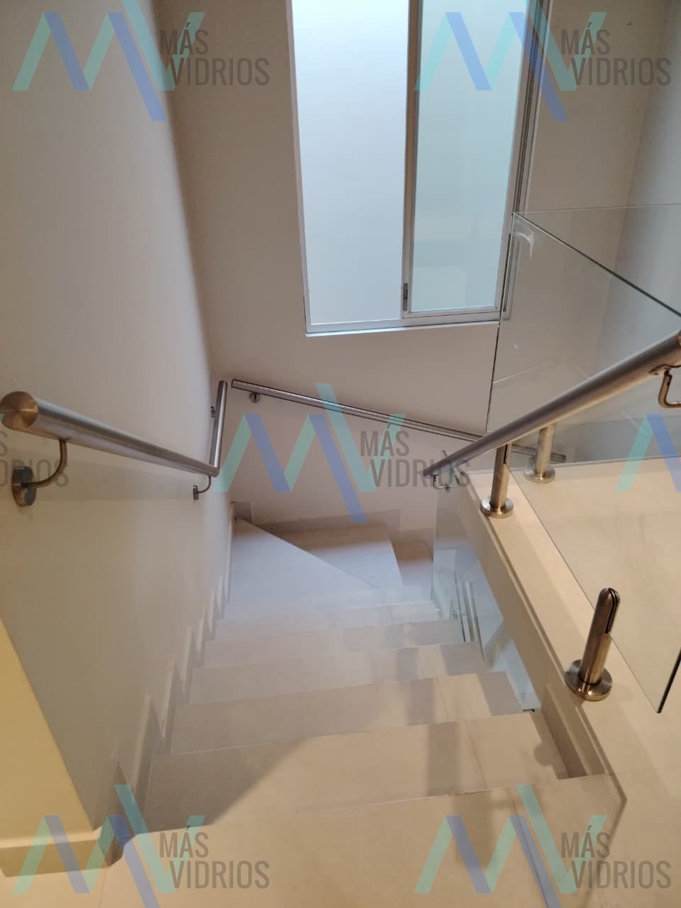 Escalera con pasamanos de acero inoxidable y baranda de vidrio en vivienda · MÁS VIDRIOS