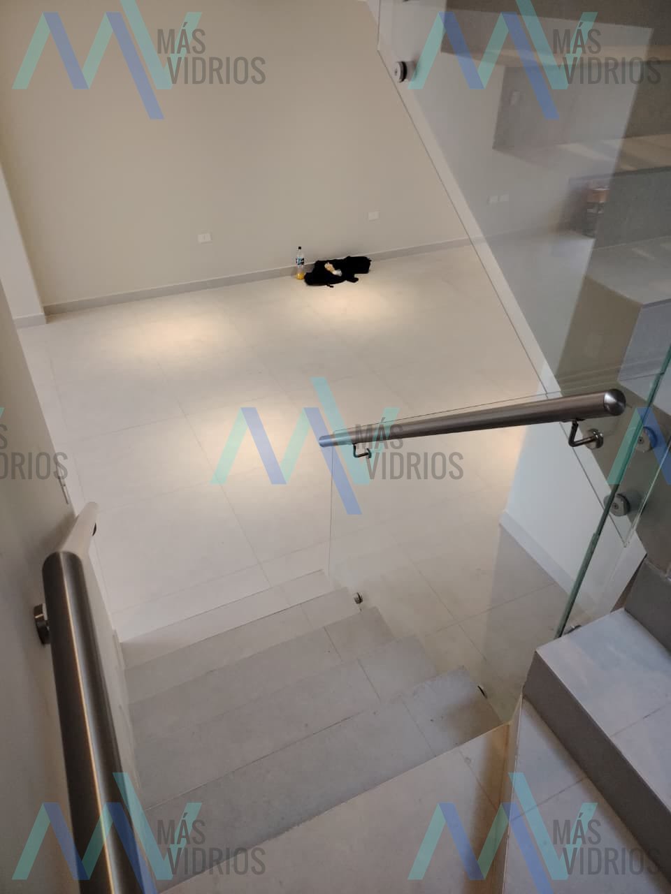 Baranda de vidrio templado con pasamanos de acero inoxidable en escalera de porcelanato · MÁS VIDRIOS