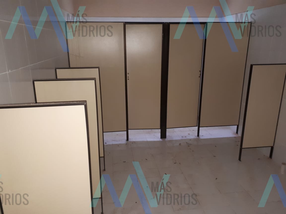 Cabinas de sanitario en Eucatex beige con estructura negra, montaje en obra · MÁS VIDRIOS