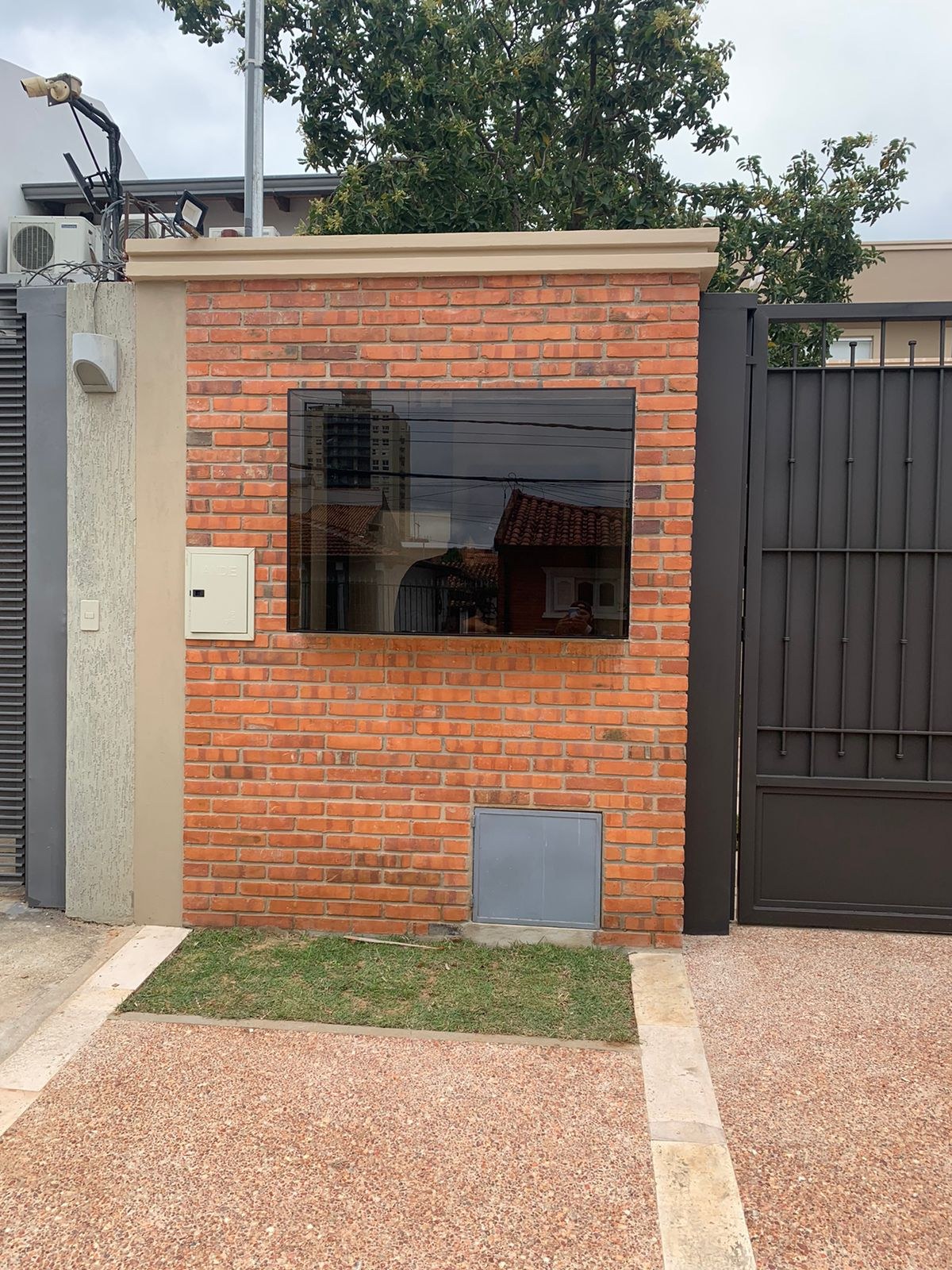 Ventana fija de vidrio oscuro en caseta de guardia de ladrillo visto · MÁS VIDRIOS
