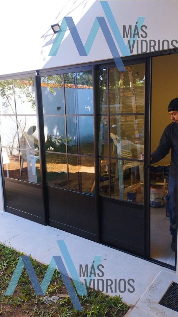 Puertas corredizas de aluminio negro estilo industrial con vidrio repartido · MÁS VIDRIOS