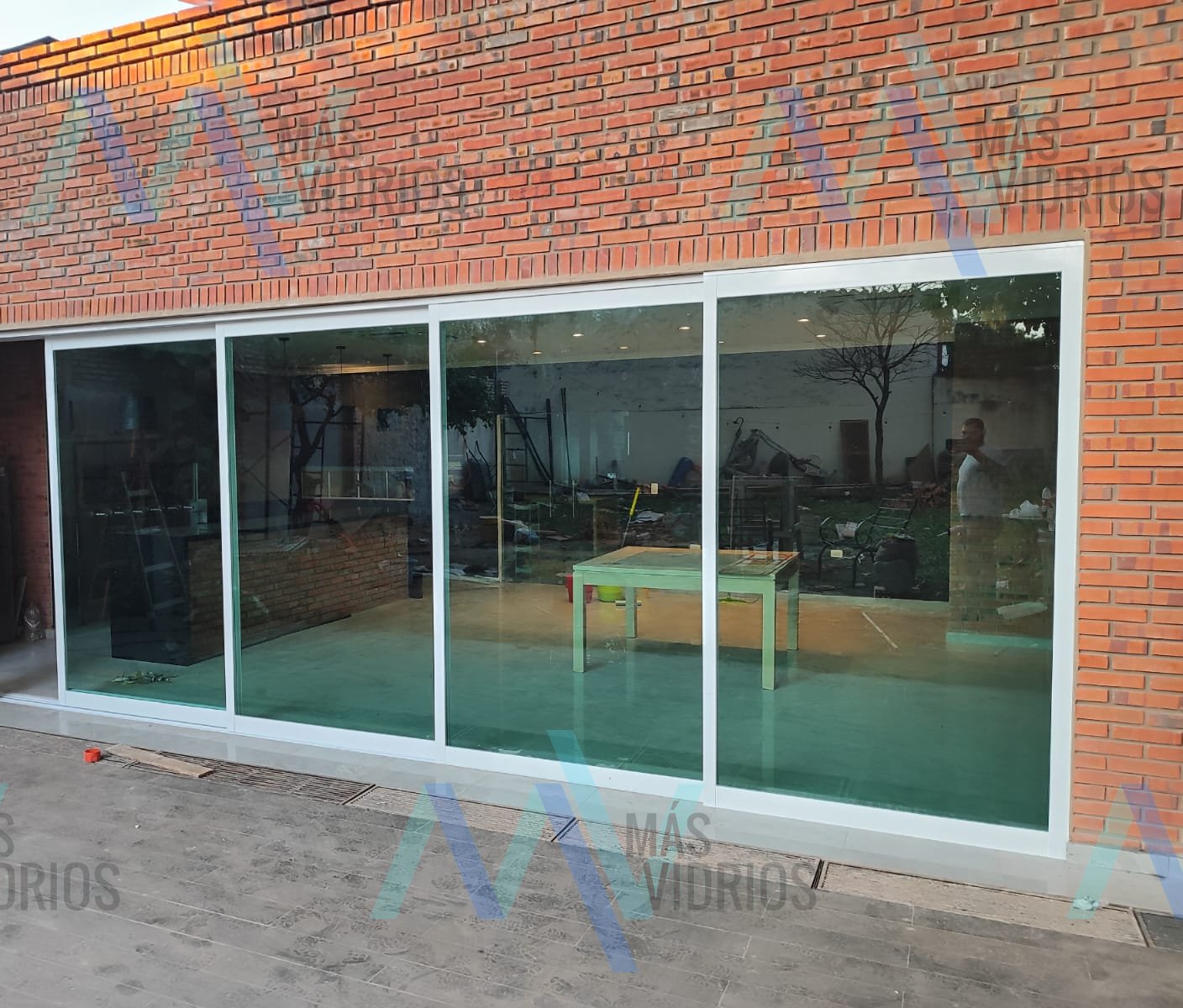 Cerramiento de vidrio con perfiles de aluminio blanco en quincho de ladrillo visto · MÁS VIDRIOS