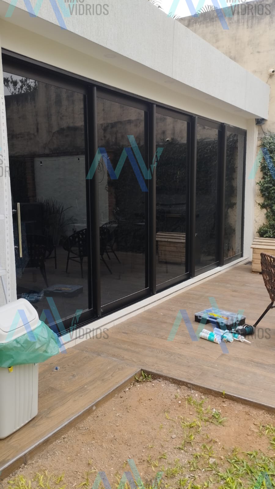 Cerramiento de vidrio con hojas corredizas de aluminio negro para quincho · MÁS VIDRIOS