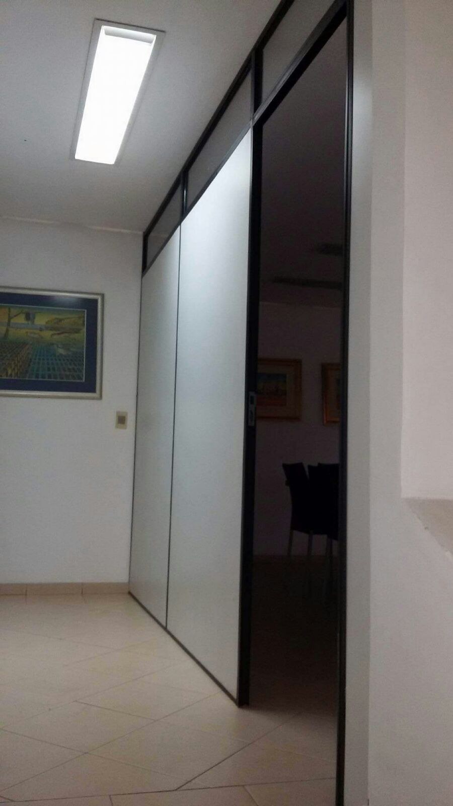 Divisoria de oficina en placa con perfilería de aluminio y puerta de paso · MÁS VIDRIOS