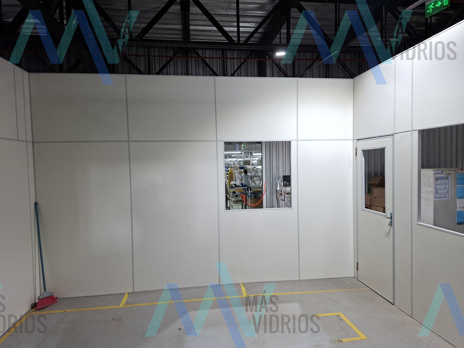 Divisoria de oficina en Eucatex blanco con puerta y ventanas dentro de una planta industrial · MÁS VIDRIOS