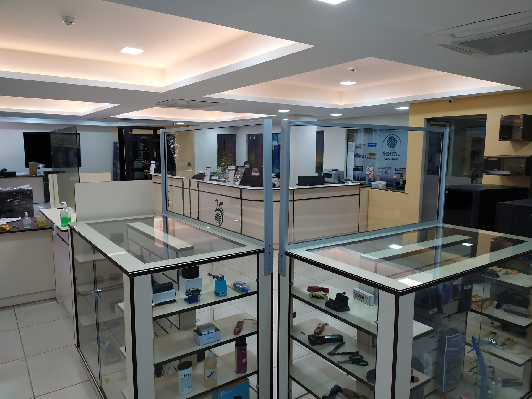 Divisorias de vidrio con perfilería de aluminio sobre los mostradores de un local comercial · MÁS VIDRIOS