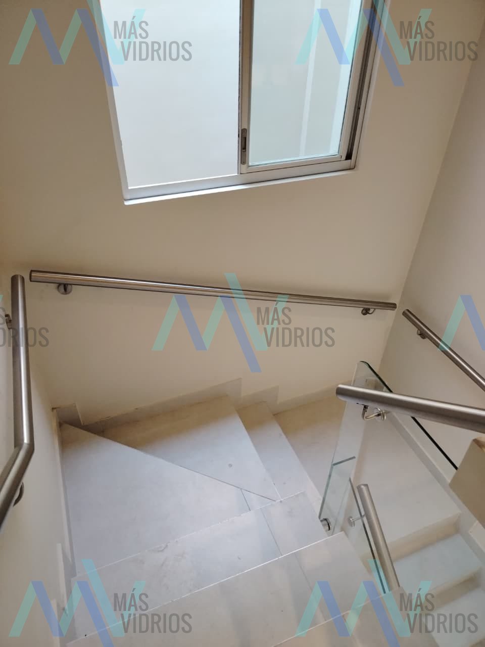 Pasamanos de acero inoxidable y baranda de vidrio en escalera interior · MÁS VIDRIOS