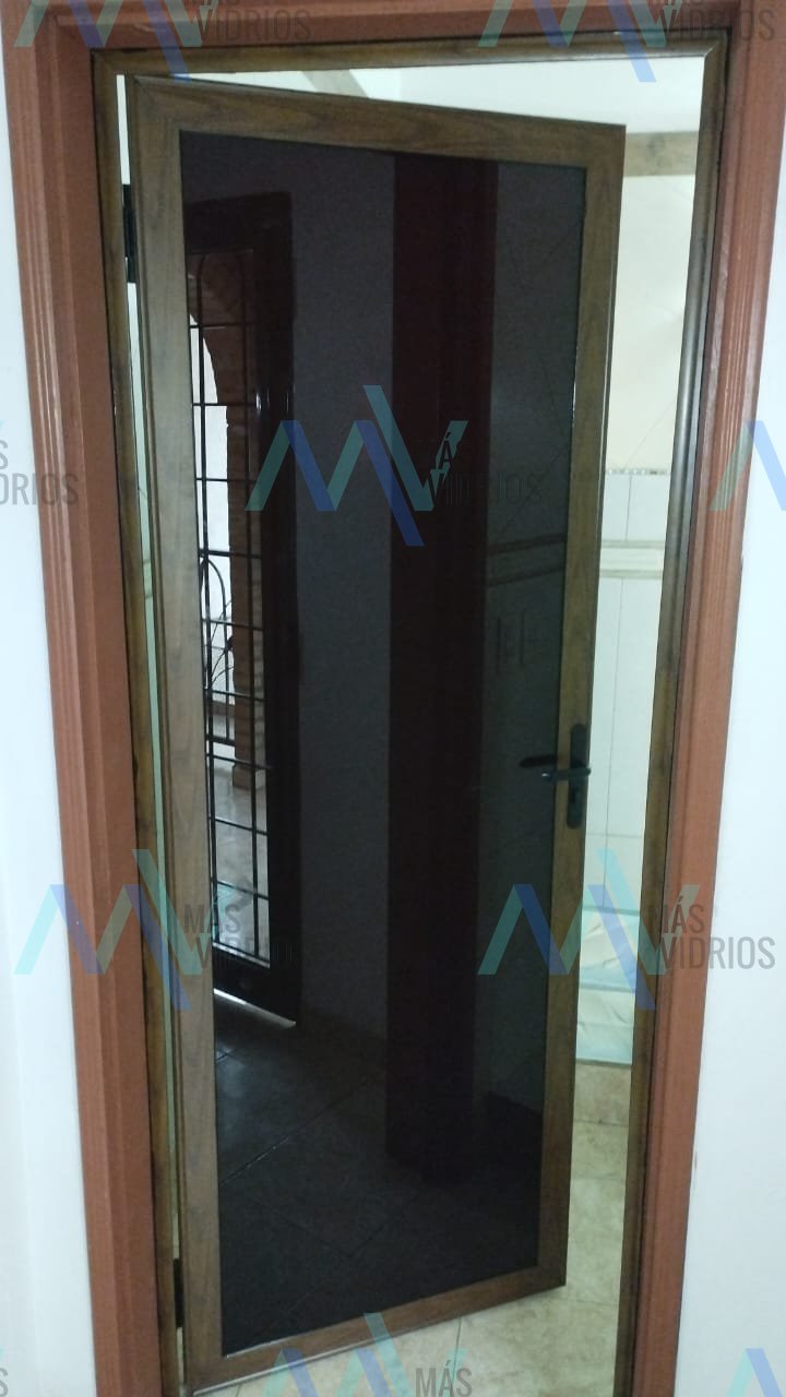 Puerta de aluminio símil madera con vidrio fumé para baño · MÁS VIDRIOS