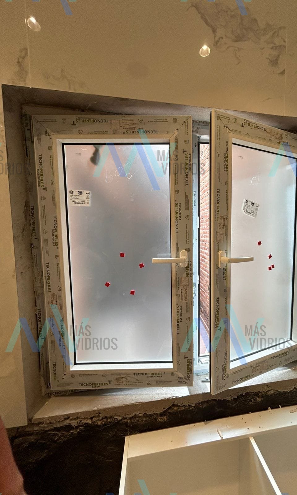 Ventanas batientes de dos hojas con vidrio esmerilado, recién colocadas y con el film de fábrica · MÁS VIDRIOS