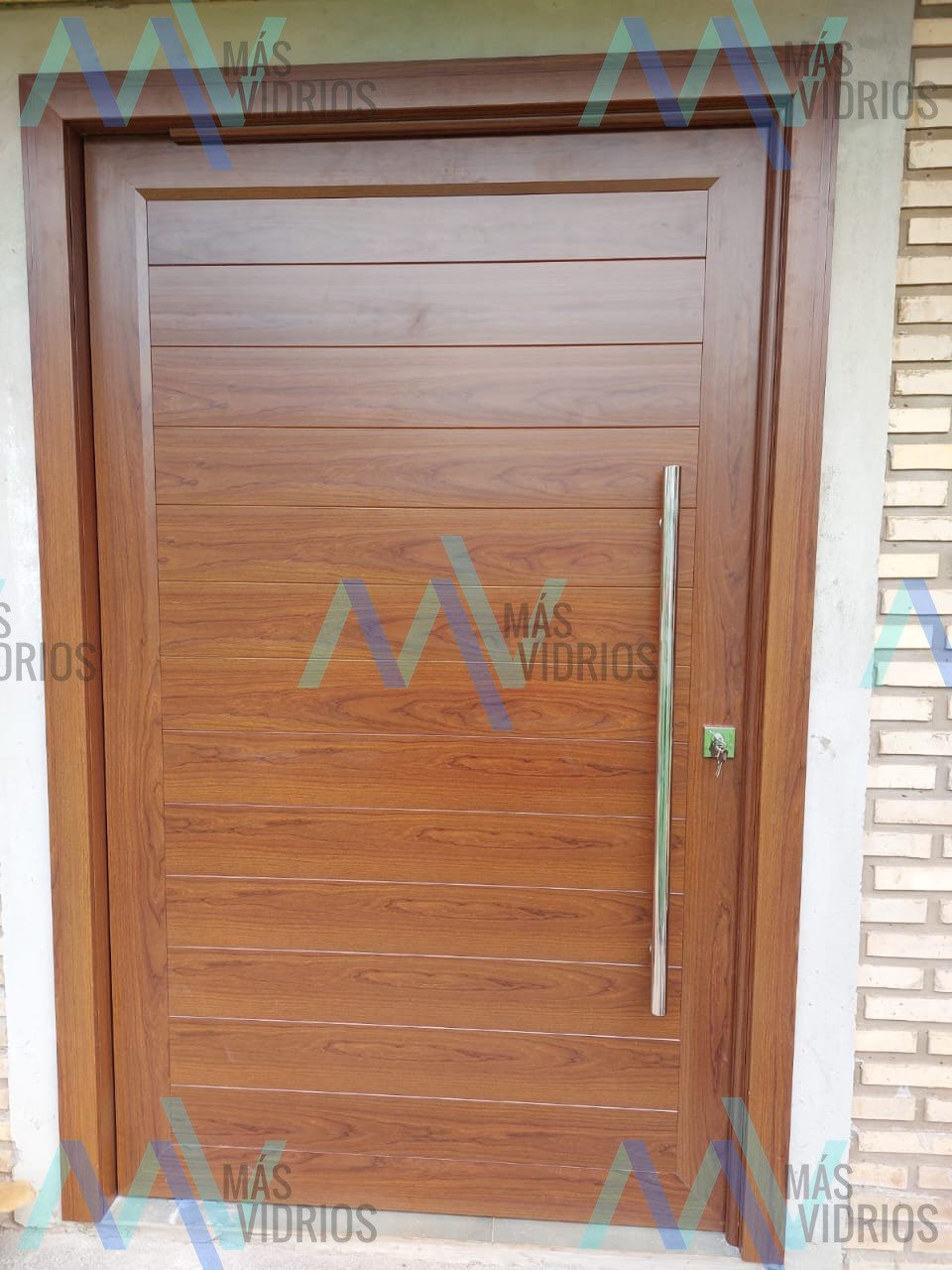 Puerta principal de aluminio símil madera con barral de acero inoxidable · MÁS VIDRIOS