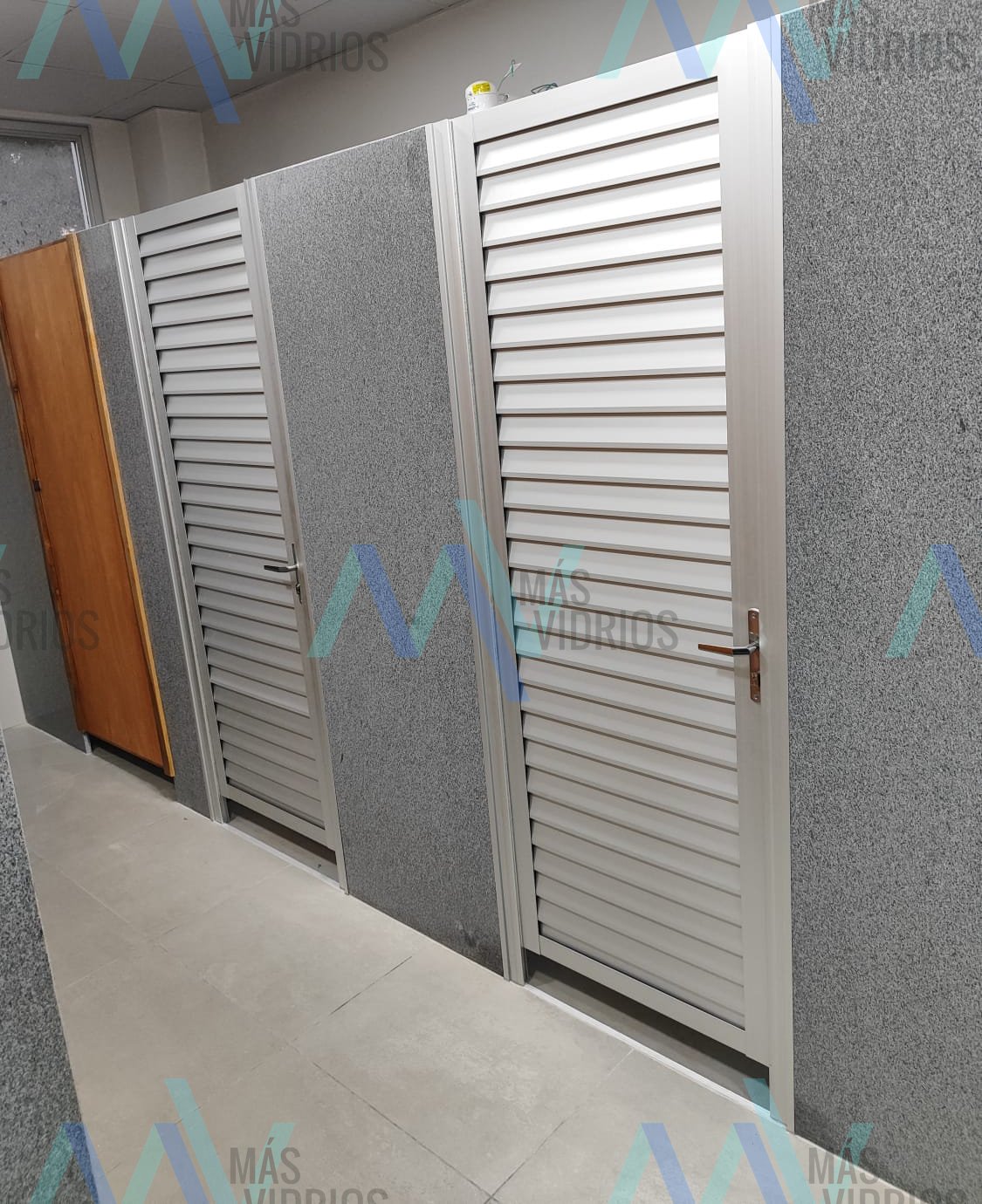Puertas de celosía de aluminio en sanitarios de local comercial · MÁS VIDRIOS