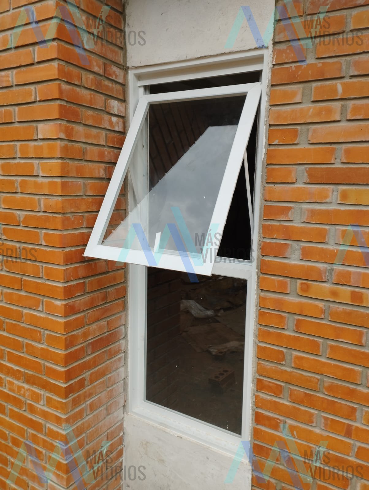 Ventana proyectante de aluminio blanco en muro de ladrillo visto · MÁS VIDRIOS