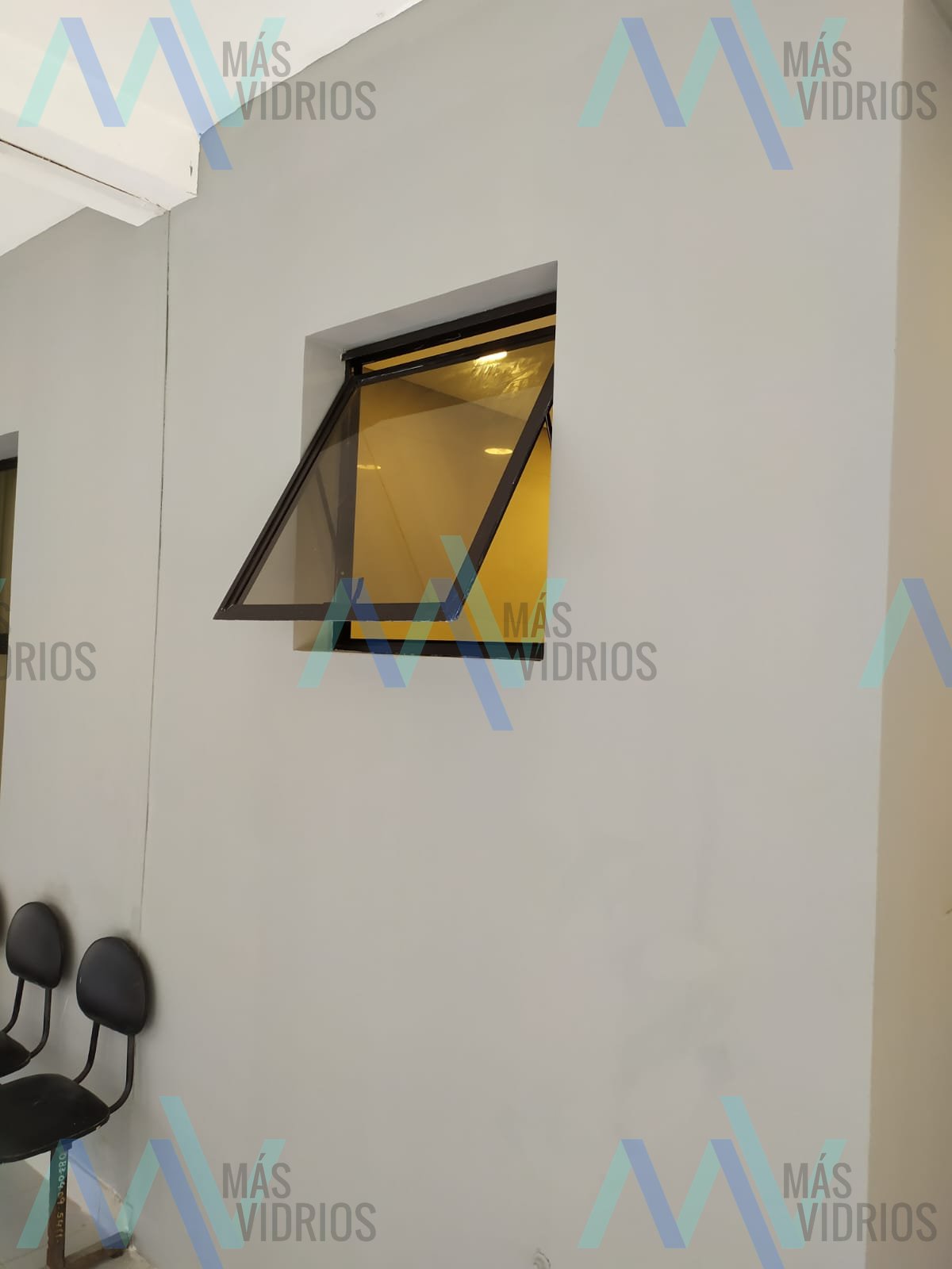 Ventana proyectante de vidrio bronce en sala de espera comercial · MÁS VIDRIOS