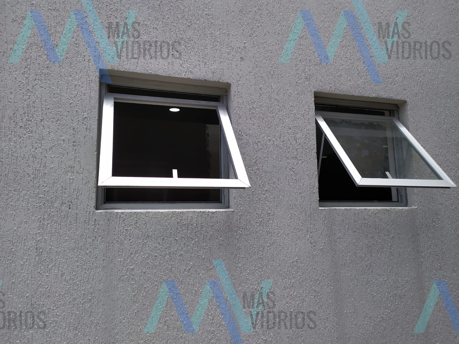 Ventanas proyectantes de aluminio en fachada con revoque texturado · MÁS VIDRIOS