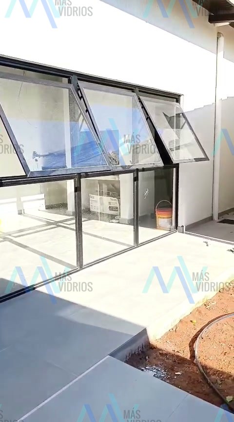 Ventanas proyectantes de aluminio negro en cerramiento de quincho · MÁS VIDRIOS