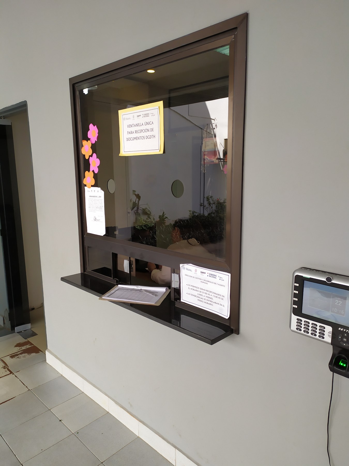 Ventanilla de recepción de documentos con marco de aluminio color bronce y repisa de granito · MÁS VIDRIOS