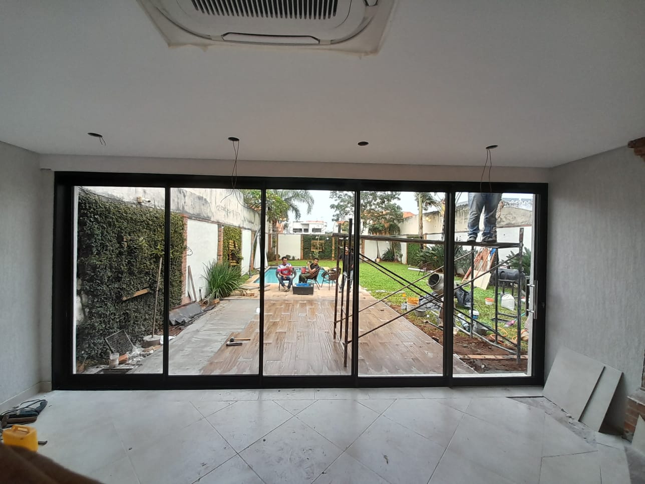 Cerramiento de vidrio corredizo en living con vista al jardín y la piscina · MÁS VIDRIOS