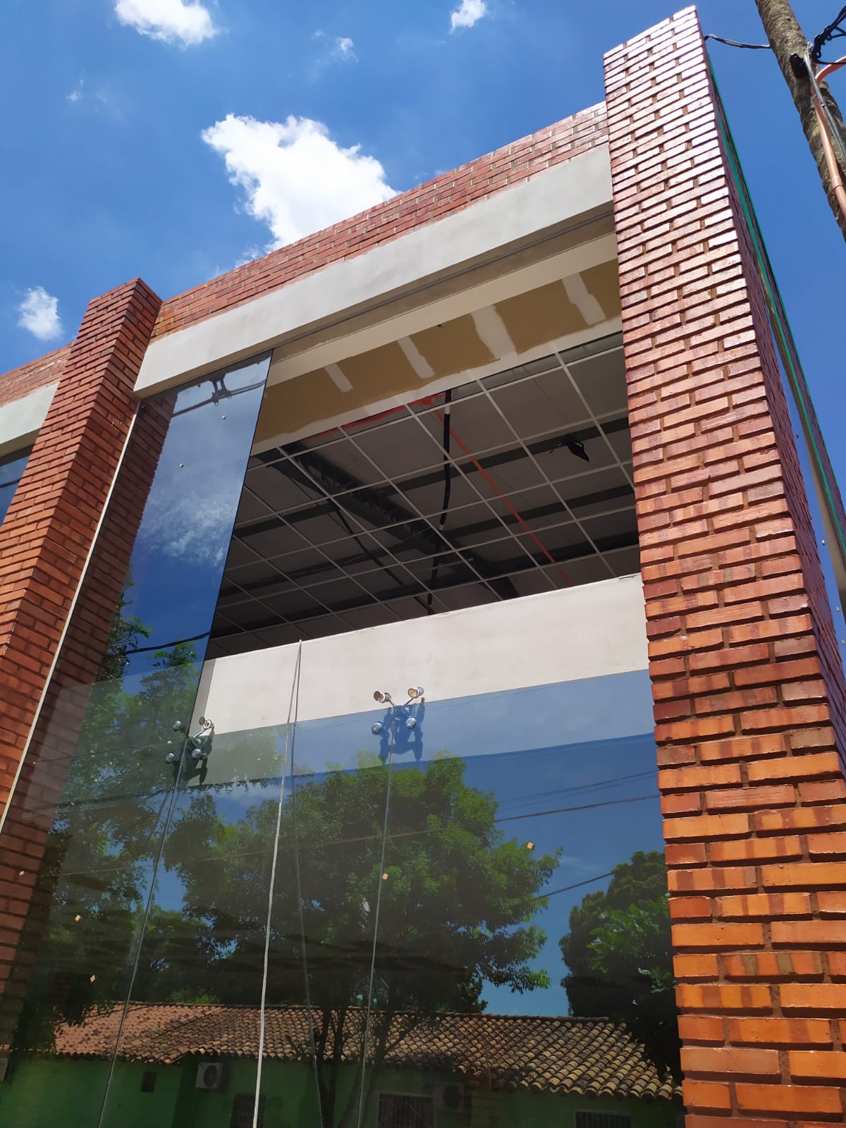 Muro cortina de vidrio en fachada de edificio con ladrillo visto · MÁS VIDRIOS